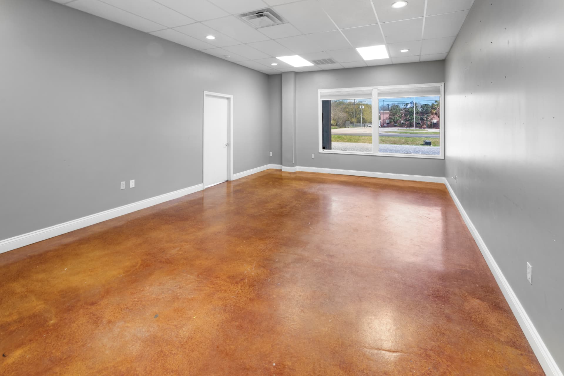 Private office with stained concrete floors and street-facing window