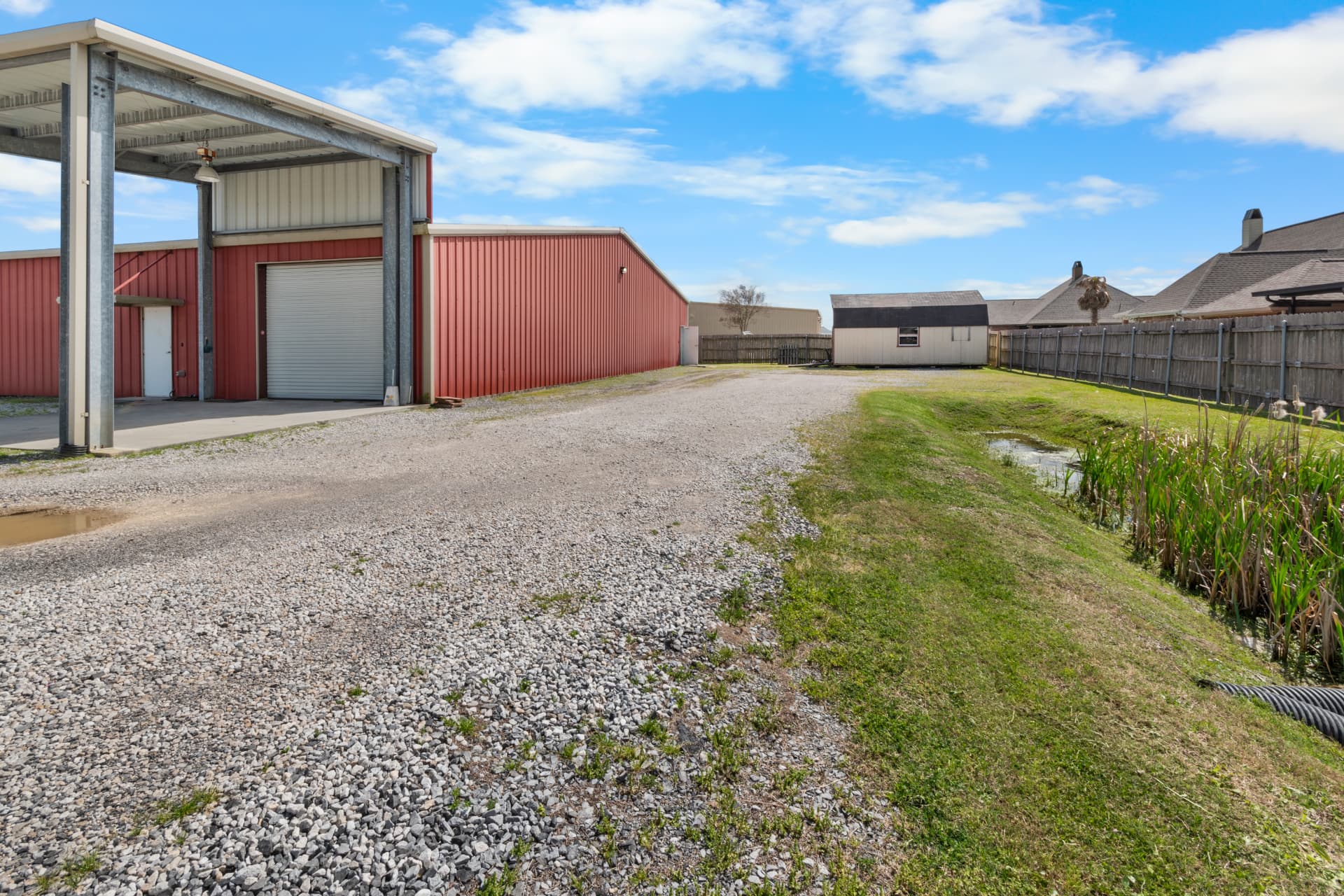 Covered drive-through canopy, roll-up overhead door and gravel yard